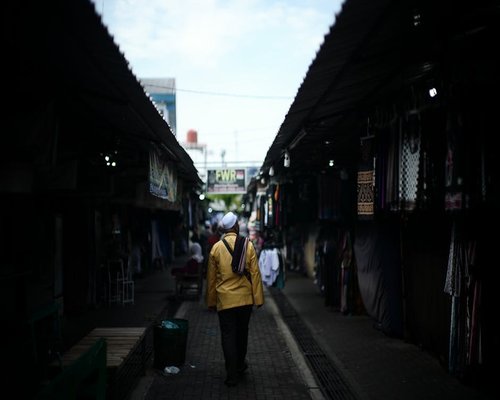 person walking to local market in indonesian neighborhood